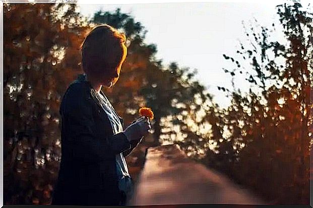 A woman holding a flower.