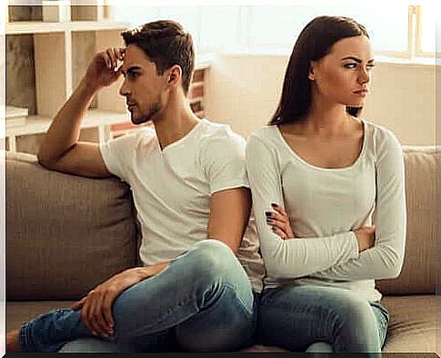 Man and woman sitting on sofa.