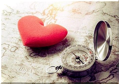 Heart and compass lying on a map.