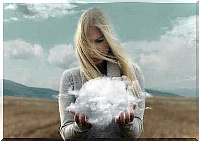 Woman standing in a field with a cloud in her hands