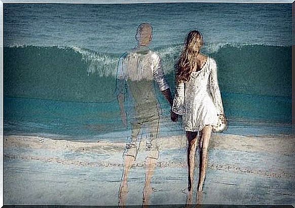 Couple holding hands by the sea.