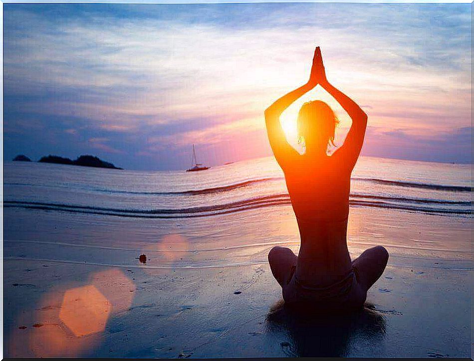 Person meditating on beach