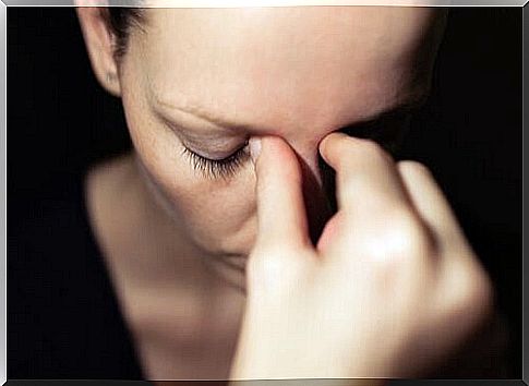 Woman pressing her fingers against her nose